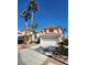 Charming two-story home featuring a tile roof, mature palm trees, and a two-car garage at 7416 Tuckaway Harbor St, Las Vegas, NV 89139