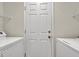 Bright laundry area with white appliances and storage shelves, and a white door at 7416 Tuckaway Harbor St, Las Vegas, NV 89139