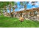 Manicured backyard featuring lush greenery, mature trees, and inviting outdoor seating at 7803 Canoe Ln, Las Vegas, NV 89145