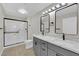 Beautiful bathroom with double sink vanity, grey cabinets, modern lighting, and tile floors at 7803 Canoe Ln, Las Vegas, NV 89145