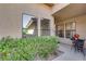 Charming home entrance, framed by lush greenery, featuring a cozy outdoor seating area at 7803 Canoe Ln, Las Vegas, NV 89145
