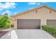 Home featuring a well-maintained two-car garage with a neutral color scheme and landscaped front yard at 7803 Canoe Ln, Las Vegas, NV 89145