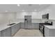 Bright kitchen features stainless steel appliances, modern grey cabinets and white marble countertops at 7803 Canoe Ln, Las Vegas, NV 89145