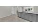 Open concept kitchen with new stainless steel dishwasher, grey cabinetry and light countertops at 7803 Canoe Ln, Las Vegas, NV 89145