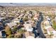 An aerial shot captures a suburban neighborhood featuring homes with swimming pools and mature trees at 793 Vortex Ave, Henderson, NV 89002