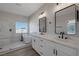 Luxurious bathroom featuring double sinks, modern lighting, and a freestanding tub next to a shower at 793 Vortex Ave, Henderson, NV 89002