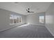 Expansive bedroom with large windows, ceiling fan, and soft gray carpet offers a comfortable, inviting space at 793 Vortex Ave, Henderson, NV 89002