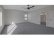 Carpeted bedroom with a ceiling fan, two windows, and access to an ensuite bathroom at 793 Vortex Ave, Henderson, NV 89002