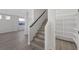 Hallway with wood-look flooring, stairs with a black handrail, and a pantry with shelves at 793 Vortex Ave, Henderson, NV 89002