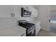 Kitchen with modern appliances, white cabinets and sliding glass door to backyard at 793 Vortex Ave, Henderson, NV 89002
