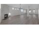Spacious living room with a stone fireplace, wood-look flooring, modern light fixture and multiple windows at 793 Vortex Ave, Henderson, NV 89002