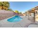 Backyard pool and spa with stone retaining wall and an outdoor patio at 793 Vortex Ave, Henderson, NV 89002