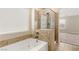 This bathroom has a garden tub with a shower and tile surround and a window for natural light at 806 Neath Ave, Las Vegas, NV 89178
