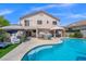 Inviting backyard features a large pool, spa, patio with seating, and a well-maintained lawn for outdoor enjoyment at 8100 Artistic Heights Ct, Las Vegas, NV 89143