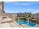 Balcony view overlooking a backyard oasis with a sparkling pool, lush landscaping, and neighboring houses at 8100 Artistic Heights Ct, Las Vegas, NV 89143