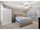 A cozy bedroom with a ceiling fan and light beige carpet for comfort at 8100 Artistic Heights Ct, Las Vegas, NV 89143