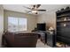 Comfortable bedroom featuring a ceiling fan, large window and a dark storage cabinet and TV for easy relaxation at 8100 Artistic Heights Ct, Las Vegas, NV 89143