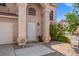 Inviting home featuring an arched entryway, well-maintained landscaping, and a two-car garage at 8100 Artistic Heights Ct, Las Vegas, NV 89143