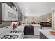 Well-lit kitchen featuring dark wood cabinetry, white appliances, and ample countertop space, seamlessly flowing into the living area at 8100 Artistic Heights Ct, Las Vegas, NV 89143