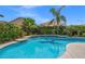 Backyard swimming pool and lounge area, landscaped with palm trees and foliage at 8100 Artistic Heights Ct, Las Vegas, NV 89143
