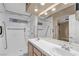 Bright bathroom featuring double sinks with white countertop and cabinets and handicap bars in shower at 897 Cavaison Ave, Las Vegas, NV 89123