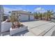 Exterior view of a single-Gathering home with a two-car garage, desert landscaping and well maintained driveway at 897 Cavaison Ave, Las Vegas, NV 89123