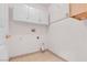 This spacious laundry room includes tile floors, overhead cabinets, and utility connections at 897 Cavaison Ave, Las Vegas, NV 89123