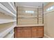 This pantry features a granite countertop, wood cabinets, and metal shelving for storing food and kitchen items at 897 Cavaison Ave, Las Vegas, NV 89123