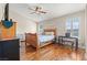 Cozy bedroom with ceiling fan, wood floors, and bright, shuttered windows at 9031 W Viking Rd, Las Vegas, NV 89147