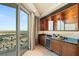 Modern wet bar with elegant cabinetry, granite countertops, wine fridge, and balcony access at 9101 Alta Dr # 1205, Las Vegas, NV 89145