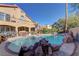 This backyard features a large pool, rock features, patio area and spiral staircase at 9909 Barrier Reef Dr, Las Vegas, NV 89117