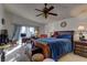 A serene bedroom featuring a vaulted ceiling, ceiling fan, and a sitting area with a desk at 9909 Barrier Reef Dr, Las Vegas, NV 89117