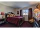 This bedroom features a dark wood bed frame, plush pillows, and a window with natural light at 9909 Barrier Reef Dr, Las Vegas, NV 89117