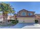 Charming two-story home with a well-manicured front yard and a two-car garage showcasing a red tile roof at 9909 Barrier Reef Dr, Las Vegas, NV 89117