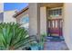 Inviting front entrance features an elegant door with glass panels, potted plants, and a brick walkway at 9909 Barrier Reef Dr, Las Vegas, NV 89117
