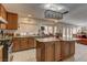 Well-equipped kitchen with wooden cabinets, an island, granite countertops, and modern appliances at 9909 Barrier Reef Dr, Las Vegas, NV 89117