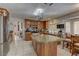 A kitchen featuring granite countertops, wood cabinetry, and a central island for food preparation and casual dining at 9909 Barrier Reef Dr, Las Vegas, NV 89117