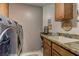 A functional laundry room with modern appliances, storage cabinets, and a sink at 9909 Barrier Reef Dr, Las Vegas, NV 89117