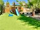 Expansive backyard with lush turf, a playset, and mature tropical trees, great for outdoor fun at , Las Vegas, NV 89121