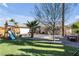 This backyard features a lush lawn, desert landscaping, a custom patio, and a charming playset at , Las Vegas, NV 89121
