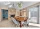 Bright dining area with a long wood table, white chairs, a fireplace, and a view of the outdoor space at , Las Vegas, NV 89121