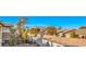 A beautiful backyard view showcasing lush greenery, neighborhood rooftops, and a backdrop of scenic mountains under a clear sky at 10466 Smokewood Rd, Las Vegas, NV 89135