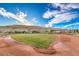 Well-maintained baseball field with green grass, a dirt track, and mountain views in the background at 10466 Smokewood Rd, Las Vegas, NV 89135