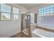 Contemporary bathroom featuring a glass-enclosed shower and soaking tub, providing a relaxing and stylish space at 10466 Smokewood Rd, Las Vegas, NV 89135