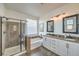 Modern bathroom with a glass-enclosed shower, separate tub, and dual vanities creating a luxurious and functional space at 10466 Smokewood Rd, Las Vegas, NV 89135