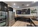 Modern kitchen boasts dark cabinets, stainless steel appliances, and stylish backsplash at 10466 Smokewood Rd, Las Vegas, NV 89135