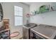 Practical laundry room with modern washer and dryer and shelving space at 10466 Smokewood Rd, Las Vegas, NV 89135