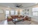 Spacious living room features a leather sectional sofa, fan, natural light, and stylish décor at 10466 Smokewood Rd, Las Vegas, NV 89135