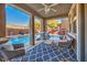 Covered patio features comfortable seating with a view of the pool and waterfall feature at 10466 Smokewood Rd, Las Vegas, NV 89135