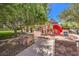 Outdoor playground with a slide and play structure surrounded by trees and landscaping at 10466 Smokewood Rd, Las Vegas, NV 89135
